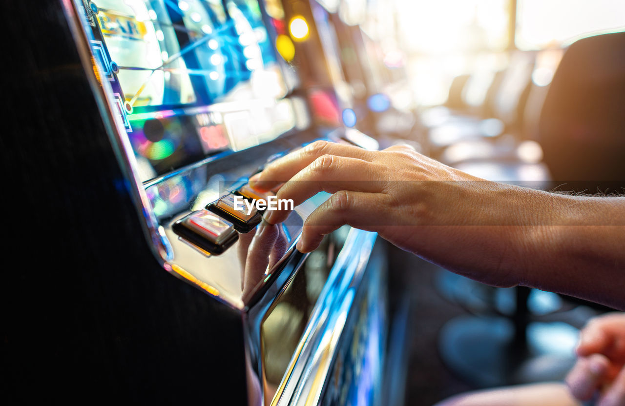 Woman playing classic slot machine inside las vegas casino. one handed bandit game play. 