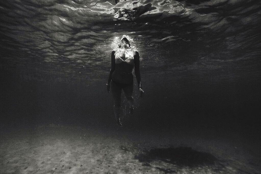 YOUNG WOMAN STANDING IN WATER