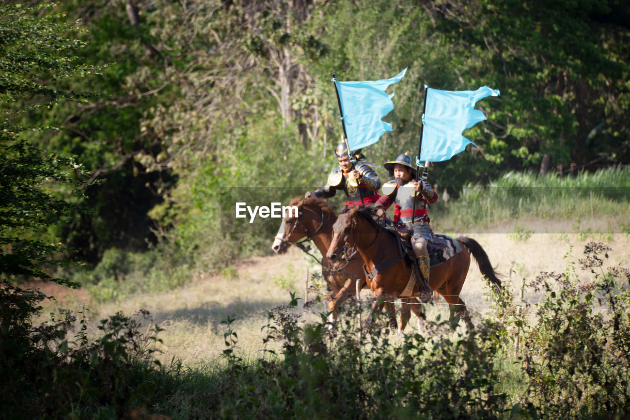 Men With Flags Riding Horses At Forest Id 138512388