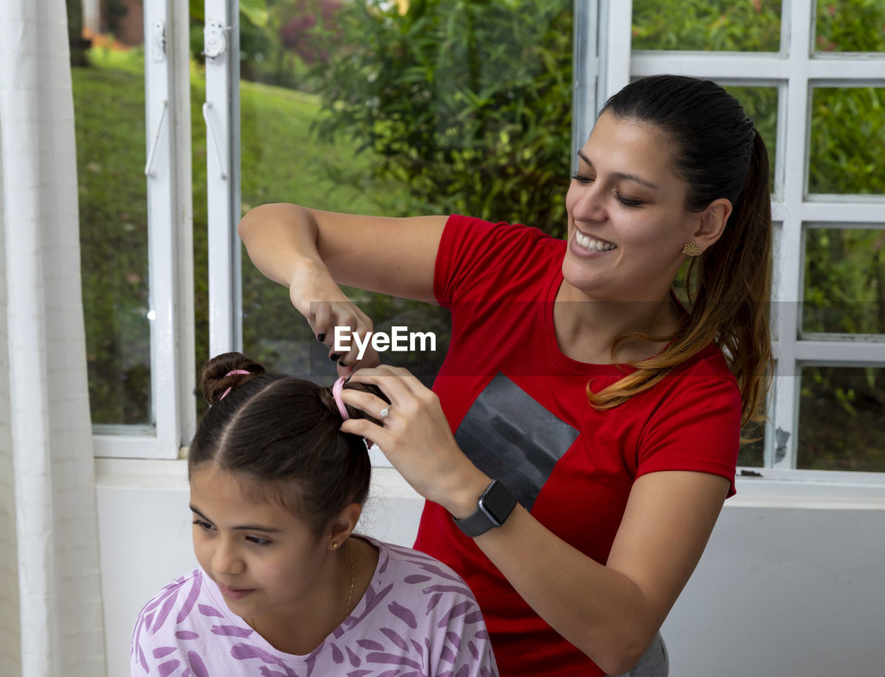 Mother tying daughter's hair