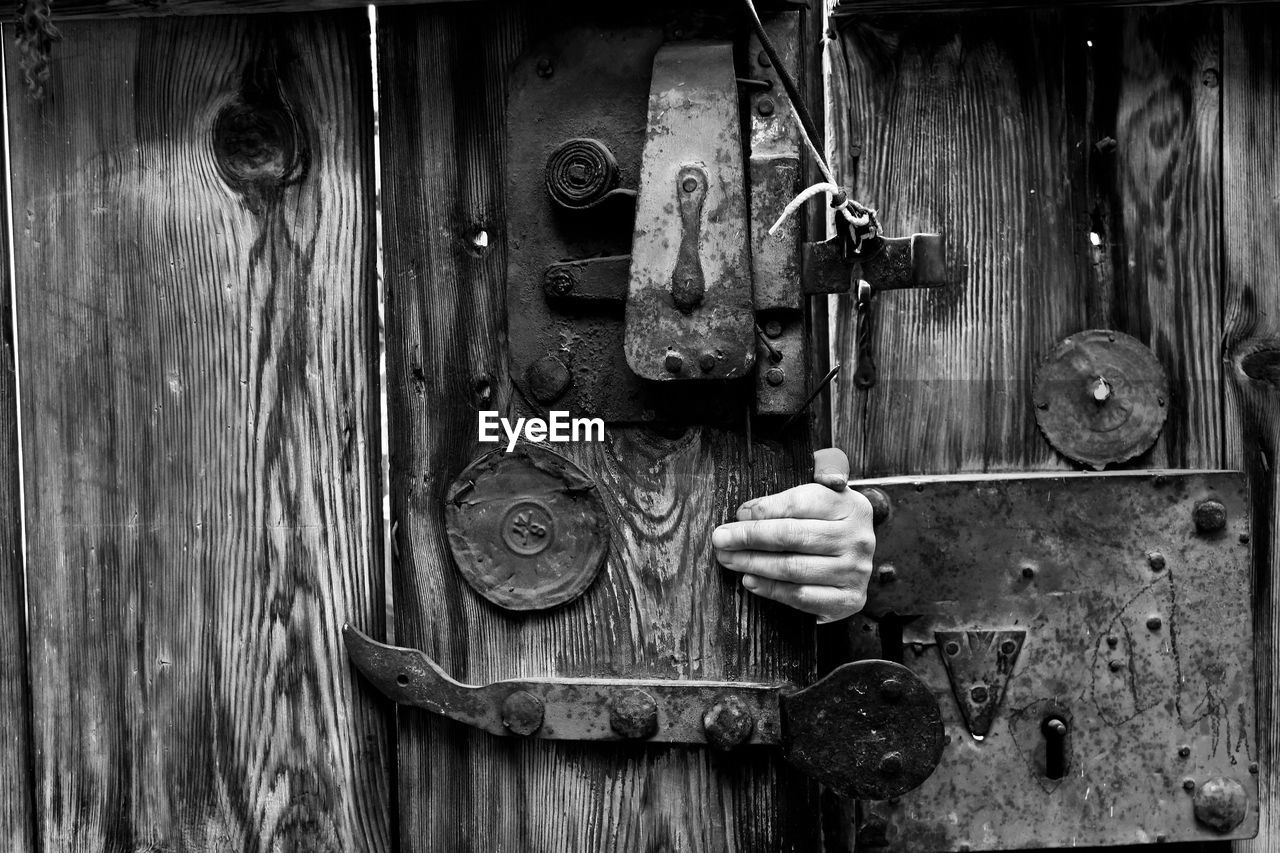 Cropped hand opening wooden door