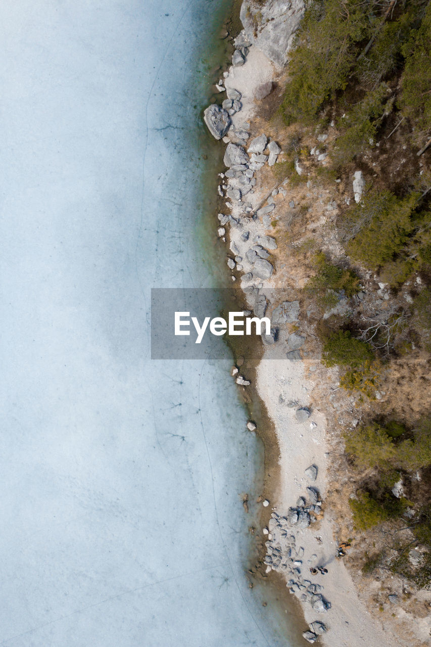 High angle view drone above frozen lake with landmark half to half