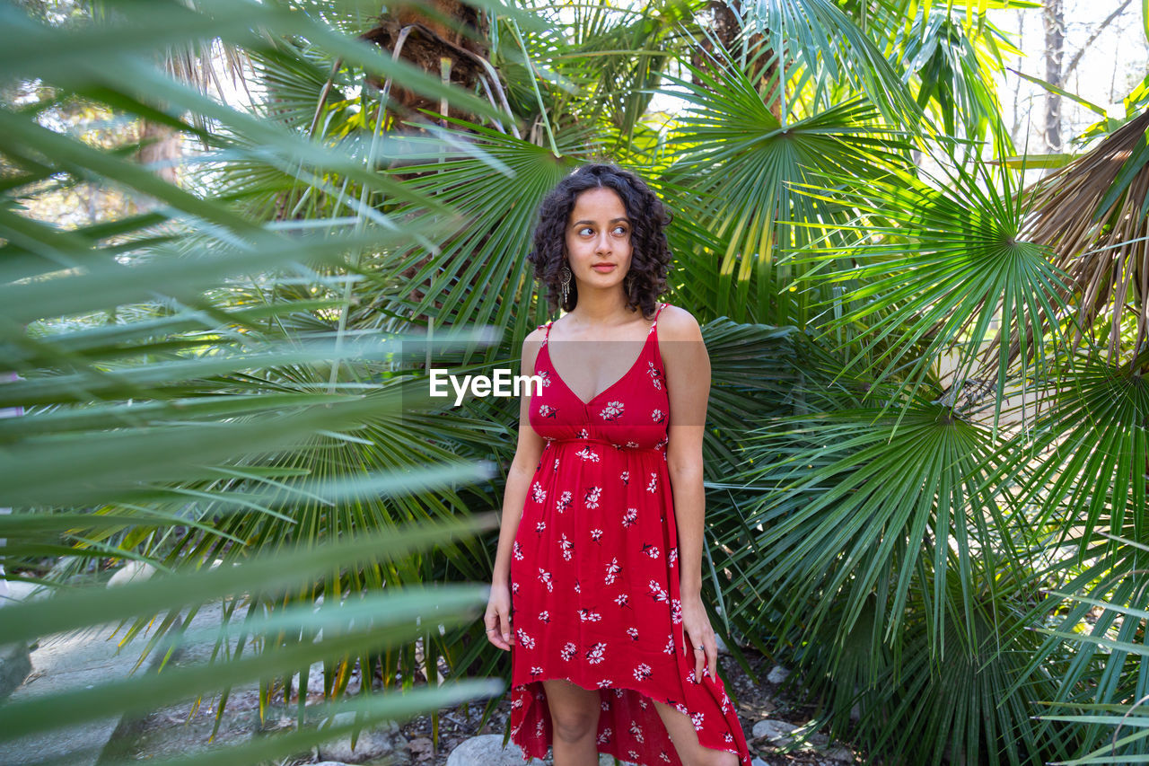 portrait of young woman standing against plants