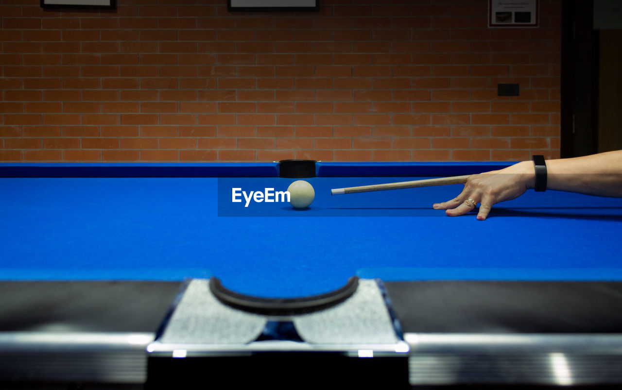Cropped hand of man playing pool