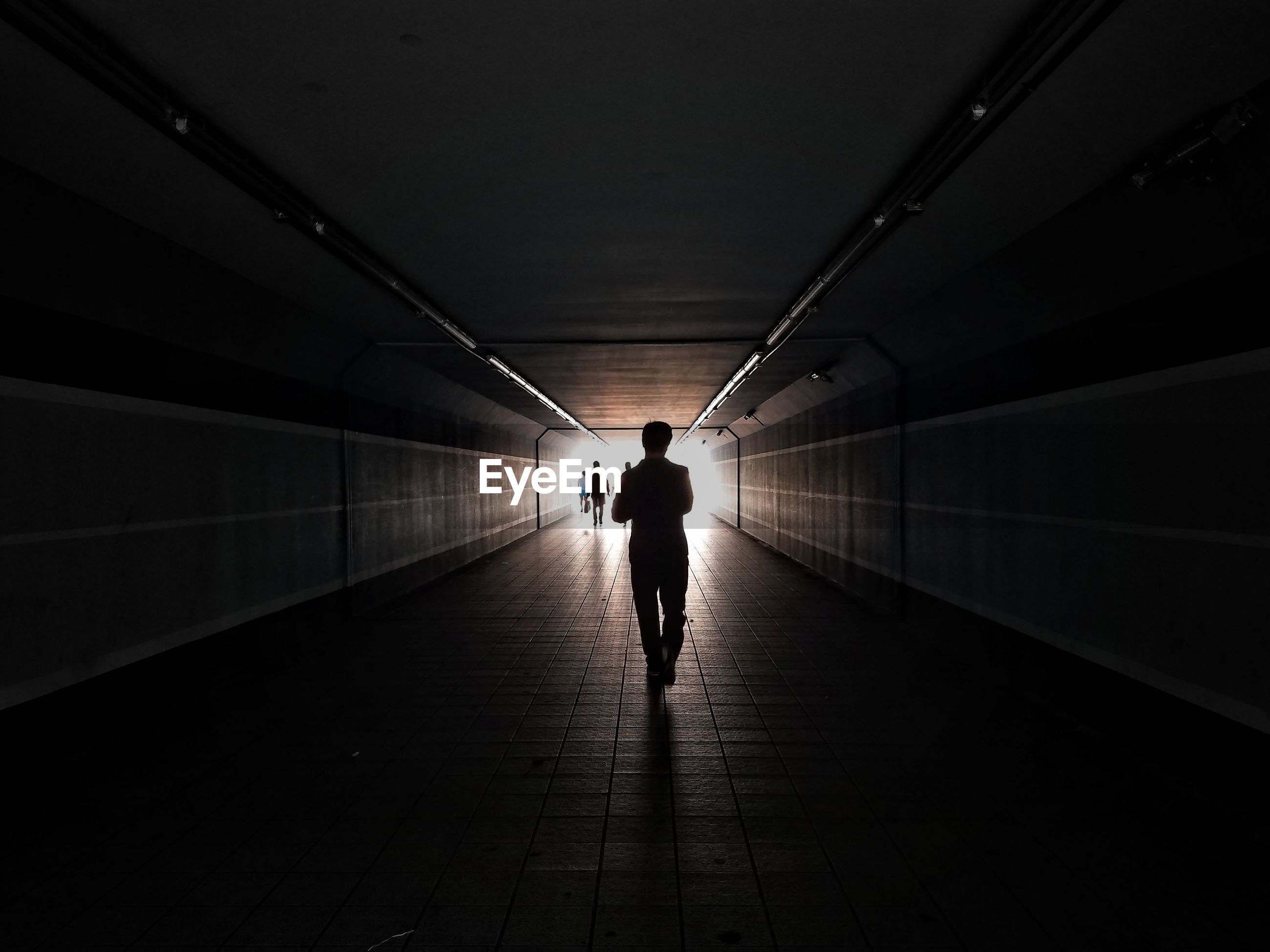 Rear view of silhouette man walking on | ID: 105045023 Silhouette Man Walking Tunnel