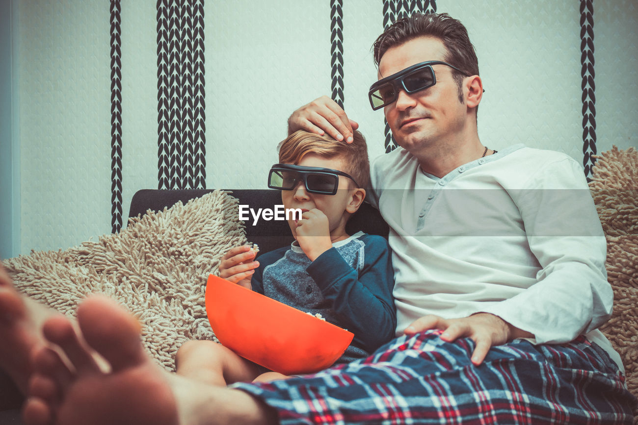 Father And Son Wearing 3d Glasses While Id 148649927