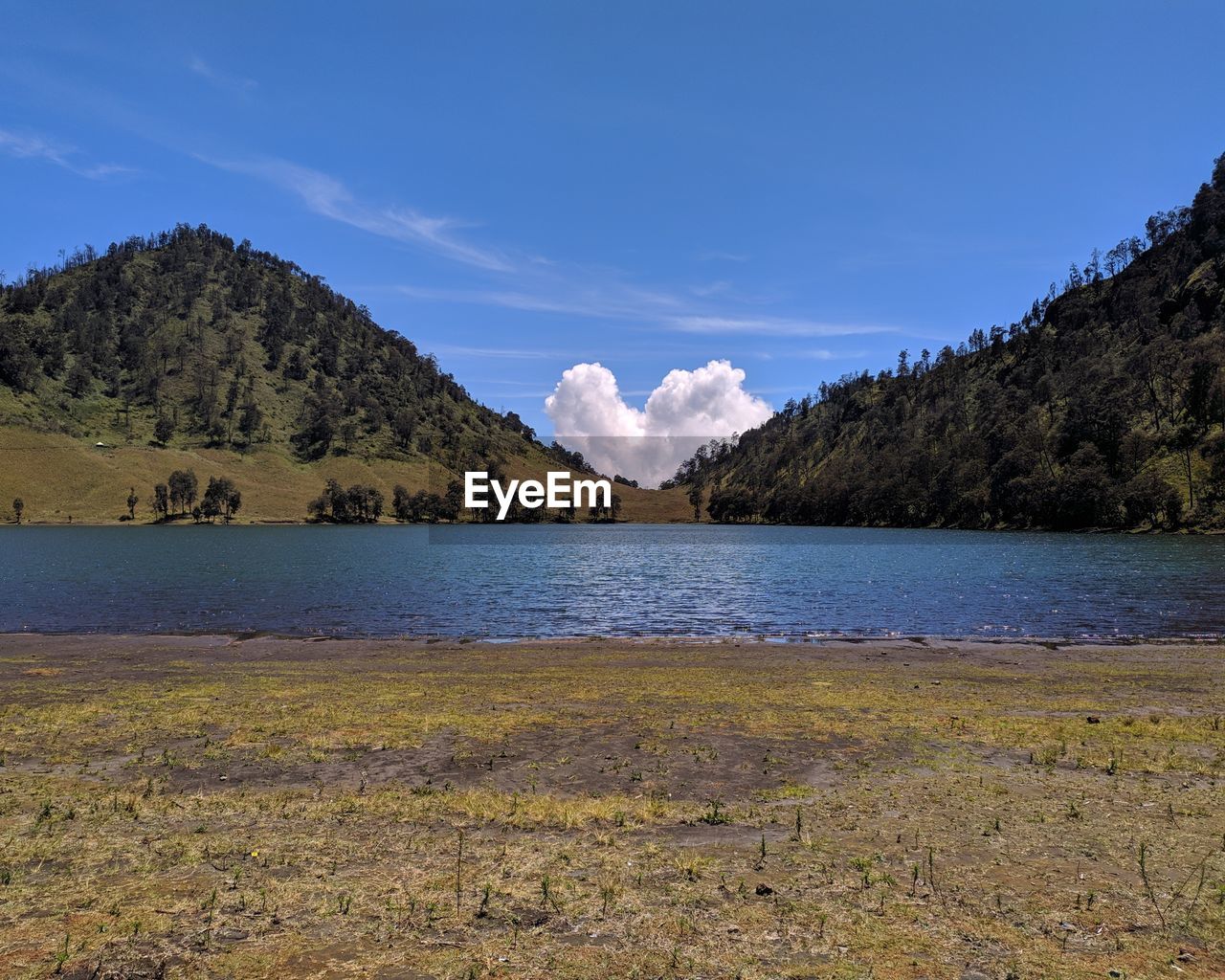 Scenic view of lake and mountains against blue sky