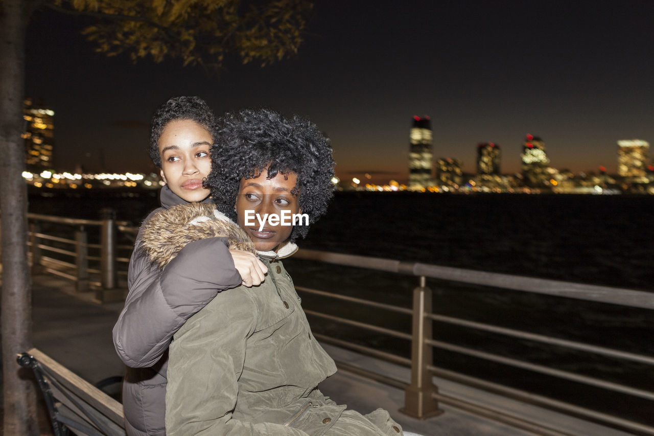PORTRAIT OF MOTHER WITH DAUGHTER AGAINST RAILING