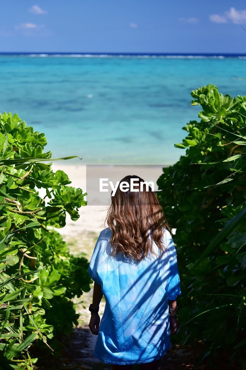 Rear view of woman looking at sea against sky