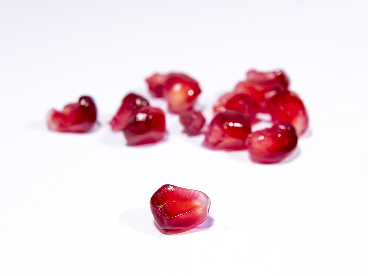 CLOSE-UP OF RED BERRIES OVER WHITE BACKGROUND