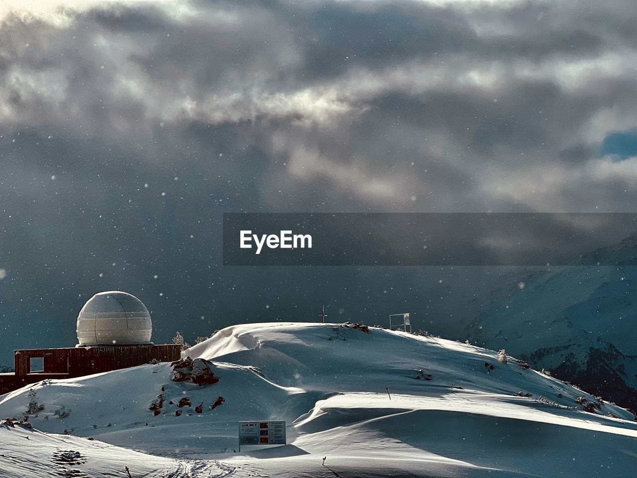 High angle view of snow covered mountain against sky at night