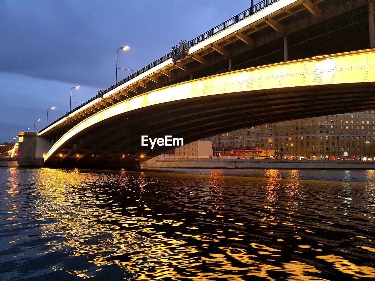 Bridge over river in city at night