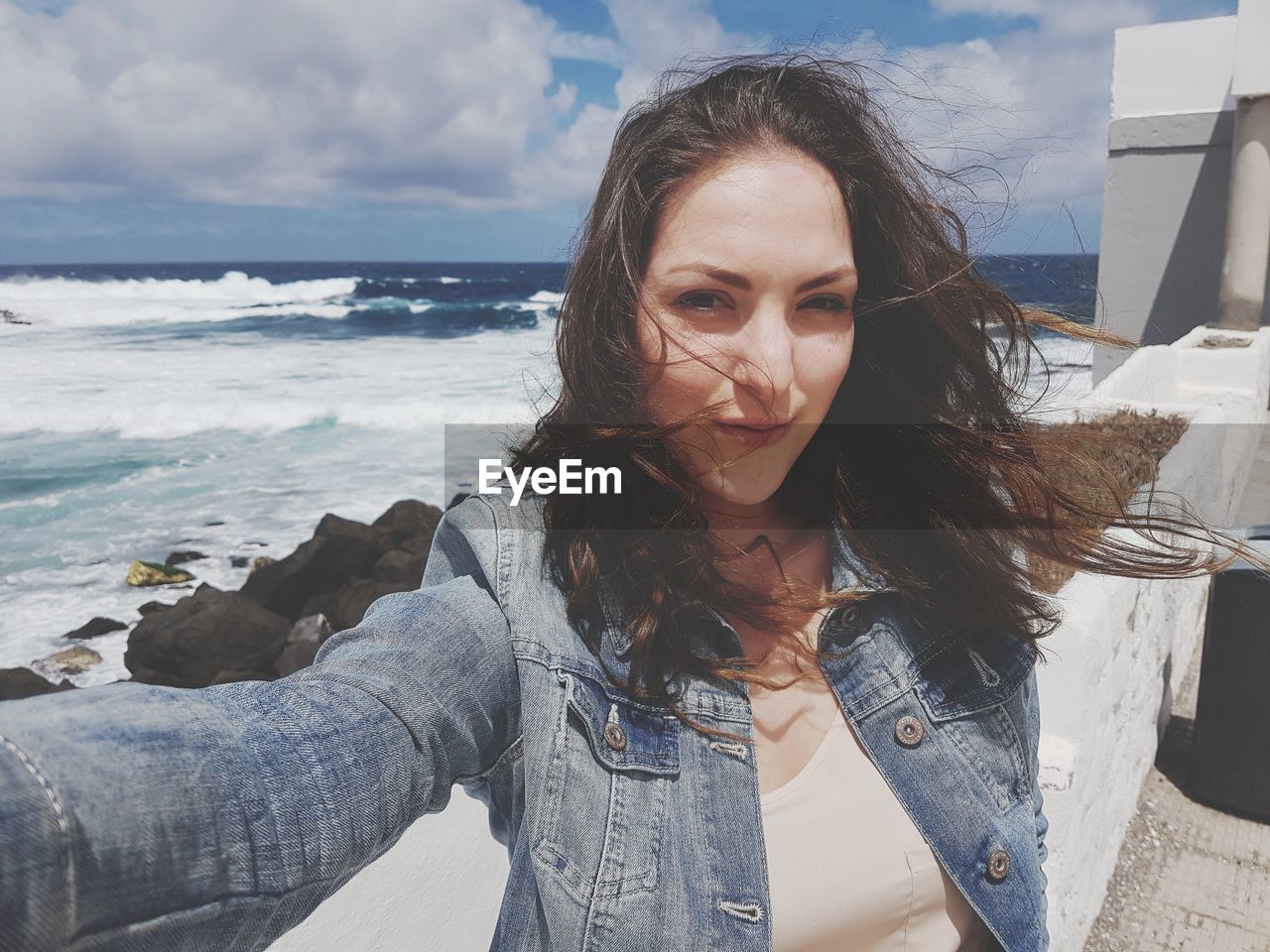 Portrait Of Young Woman With Tousled Hair Against On Eyeem