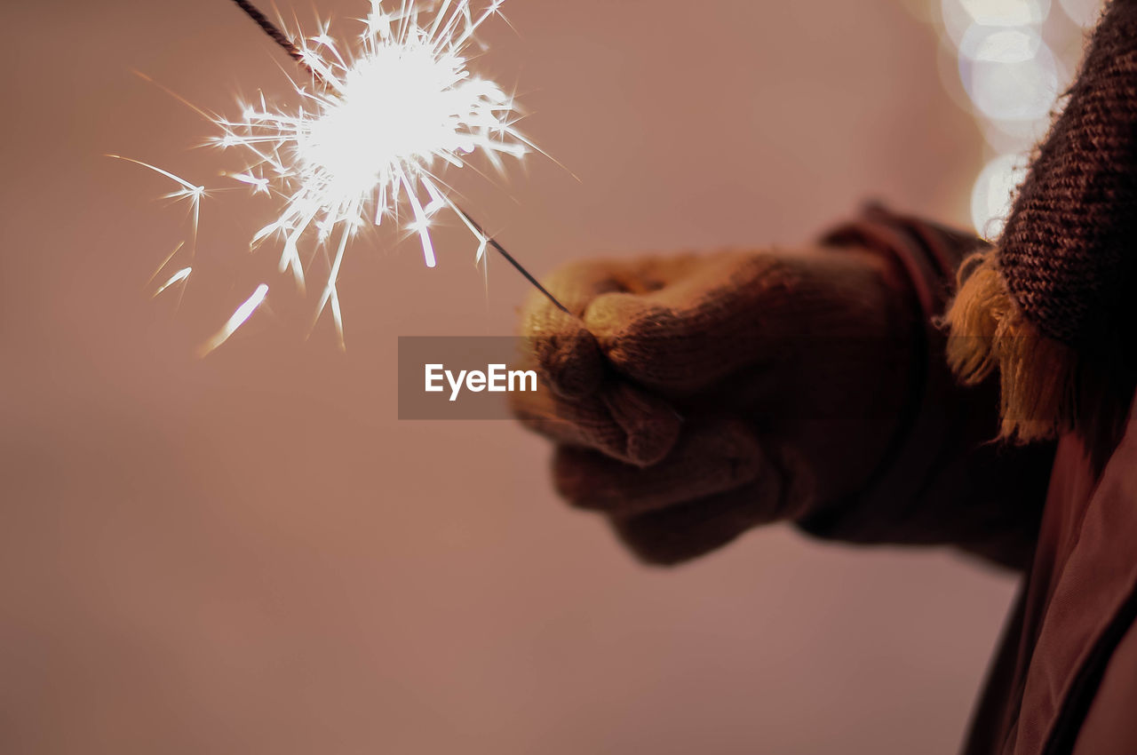 Close-up of hand holding sparkler at night