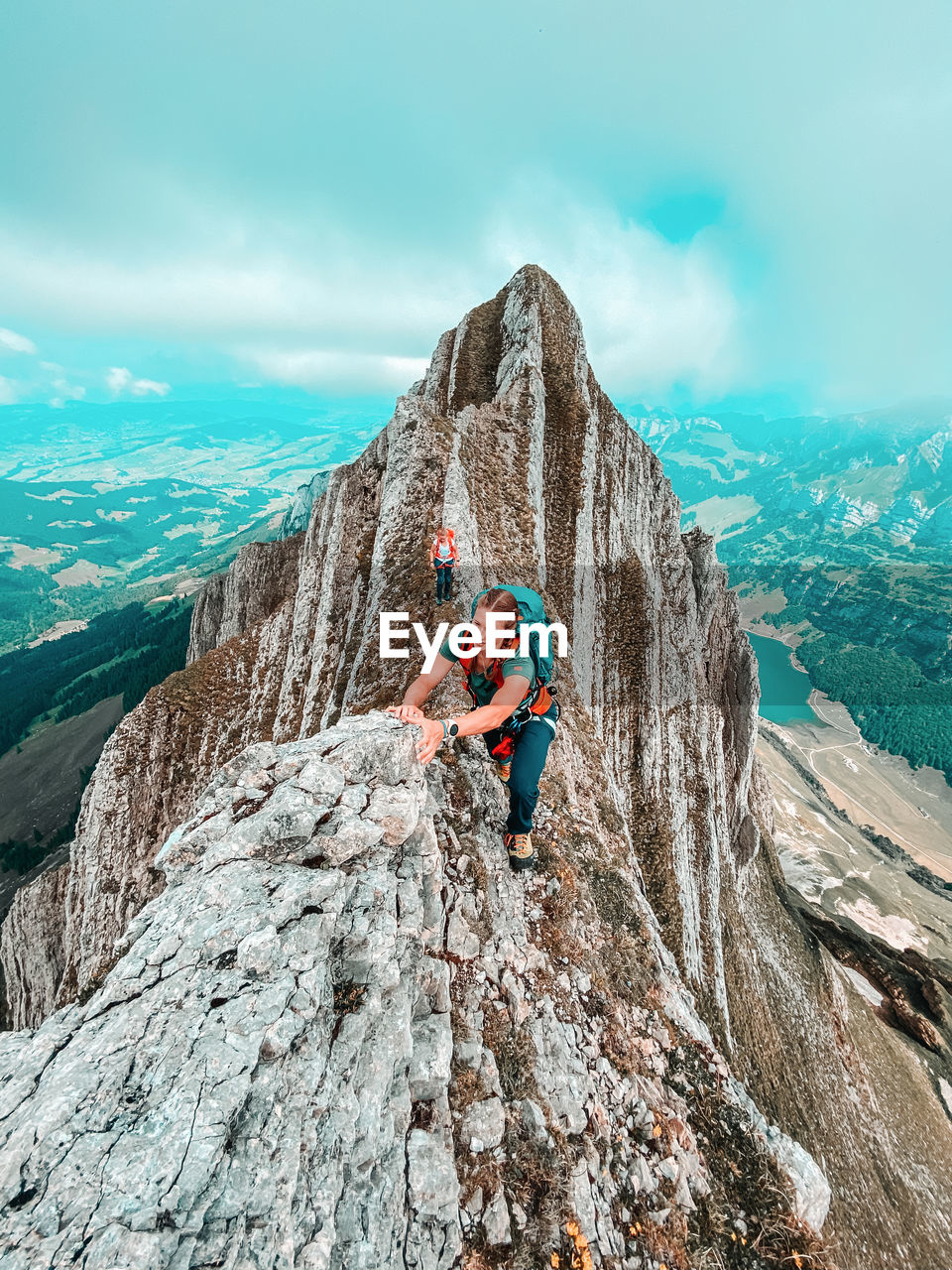 MAN STANDING ON ROCK AGAINST MOUNTAINS