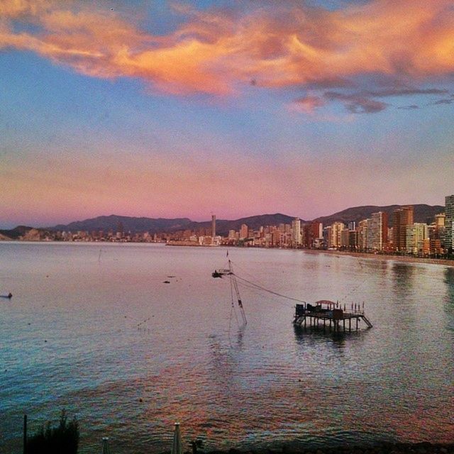 water, sky, sunset, evening, dusk, cloud, nautical vessel, transportation, architecture, nature, sea, built structure, mode of transportation, reflection, city, building exterior, beauty in nature, scenics - nature, ship, bay, travel destinations, no people, shore, travel, horizon, tranquility, mountain, outdoors, building, vehicle, tranquil scene, afterglow, waterfront, dramatic sky