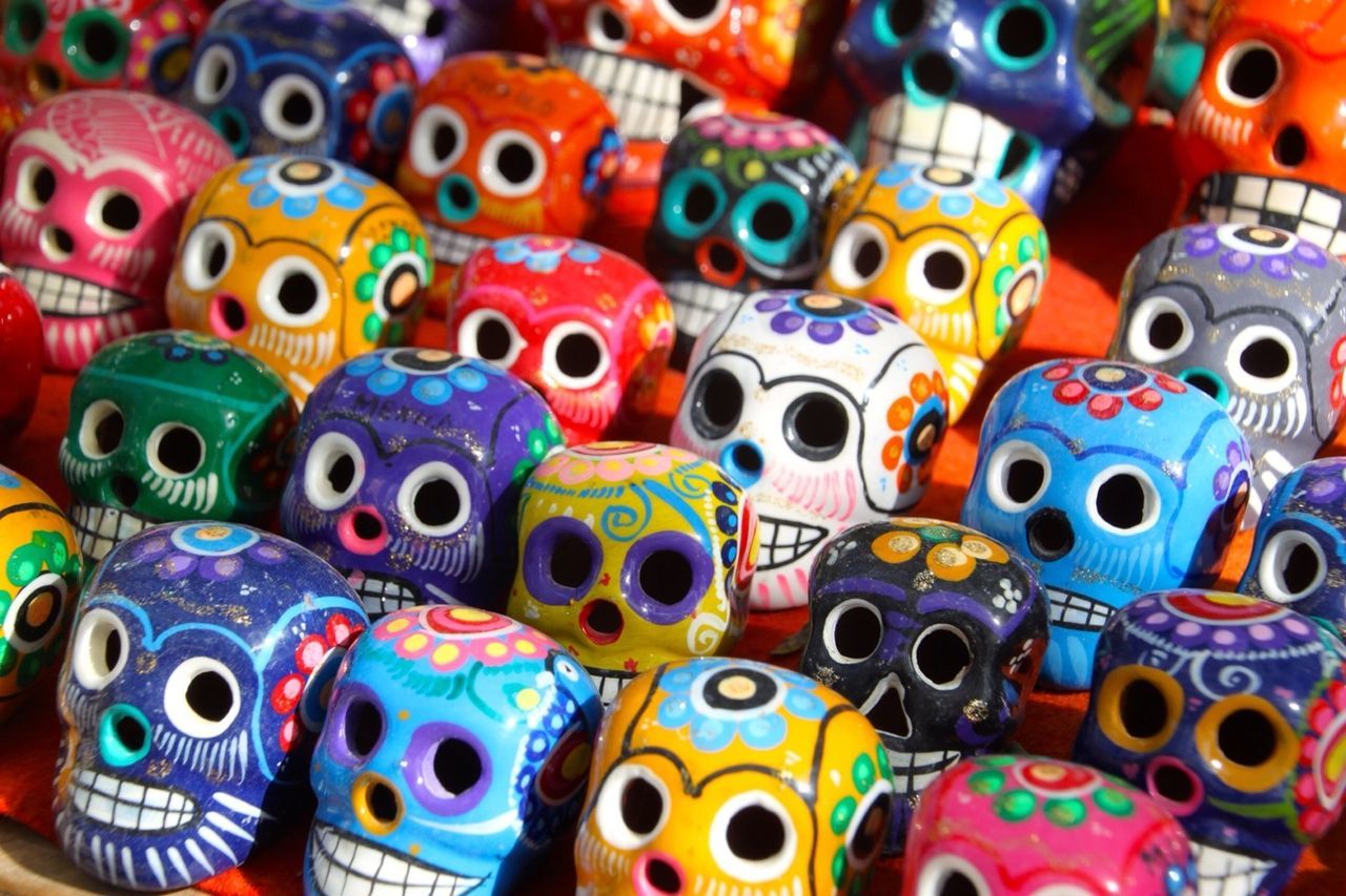 Rows of multi colored ceramic skulls for sale