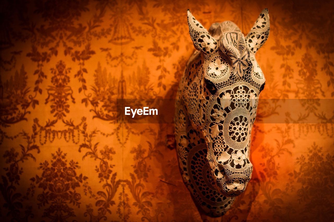 Close-up of creative horse shape decor mounted on patterned wall