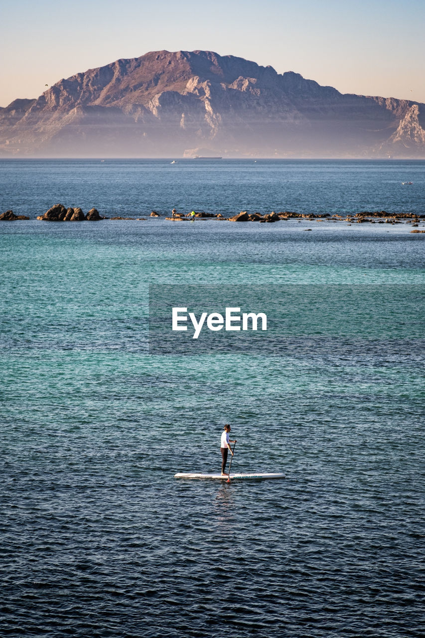 Scenic view of sea by mountain against sky. paddlesurf strait of gibraltar. 