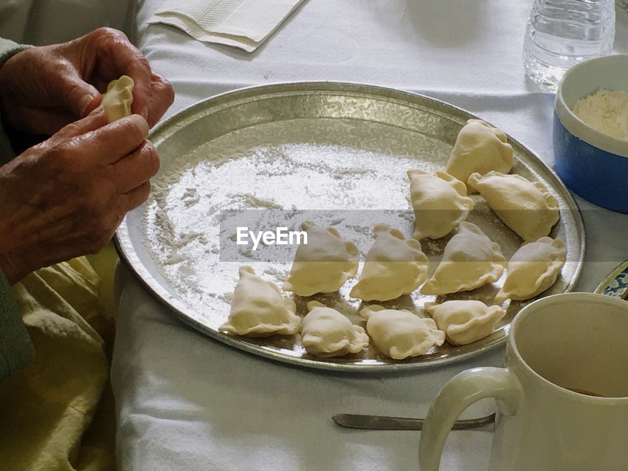 Cropped image of hand making pierogi in kitchen