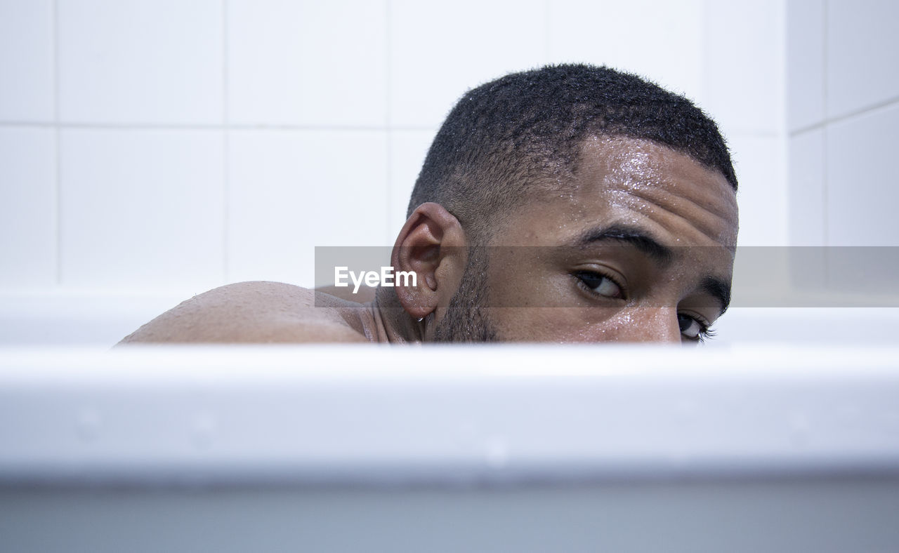 PORTRAIT OF YOUNG MAN IN BATHTUB