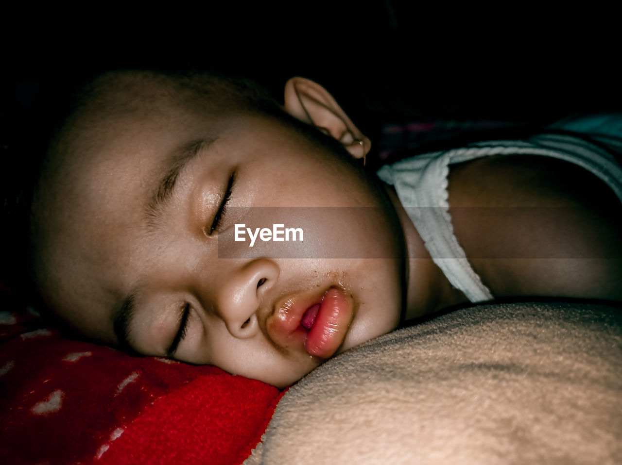 CLOSE-UP PORTRAIT OF BABY SLEEPING ON BED