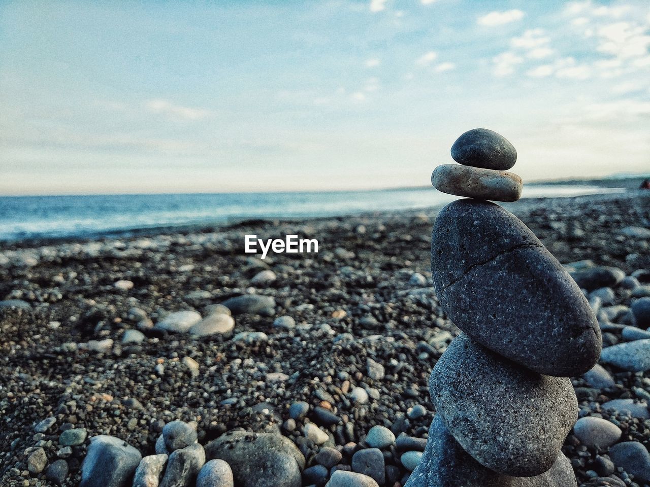 Stack of stone at beach against sky