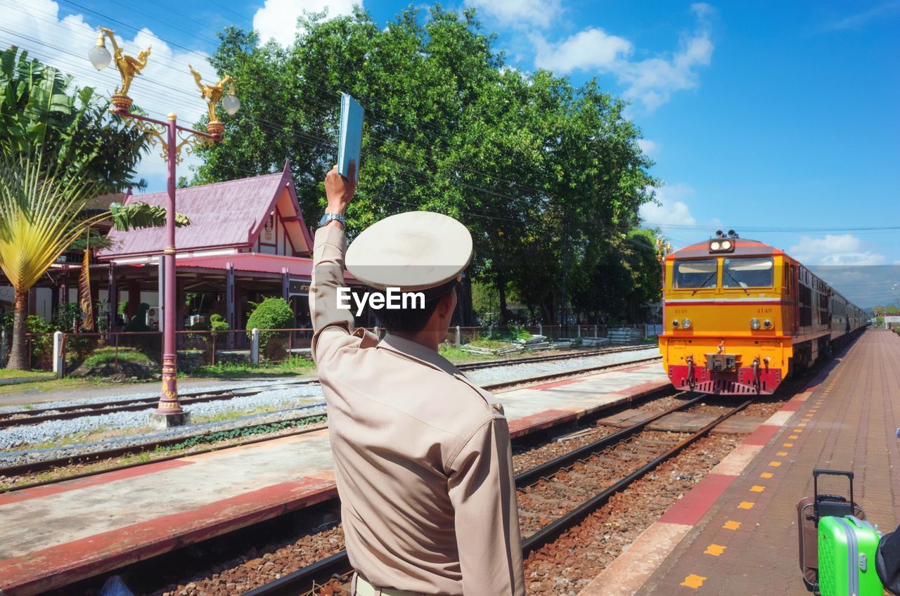 Man standing train in city against sky