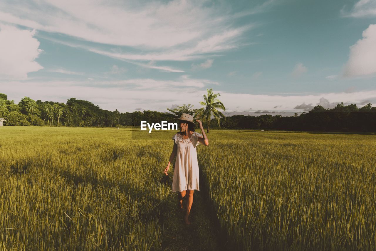 Woman standing on field against sky
