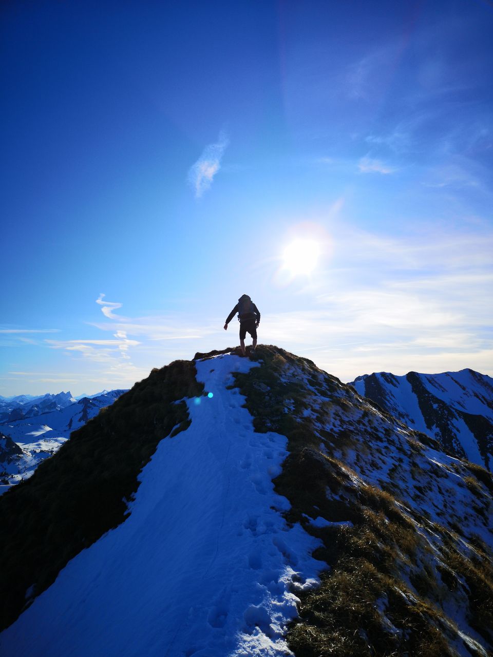 MAN ON SNOWCAPPED MOUNTAINS AGAINST SKY
