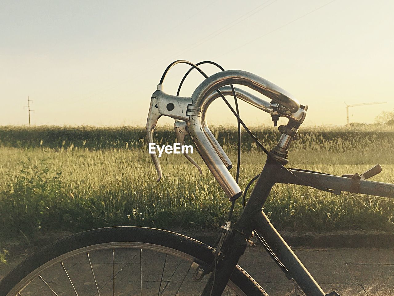 Close-up of cropped bicycle against grassland