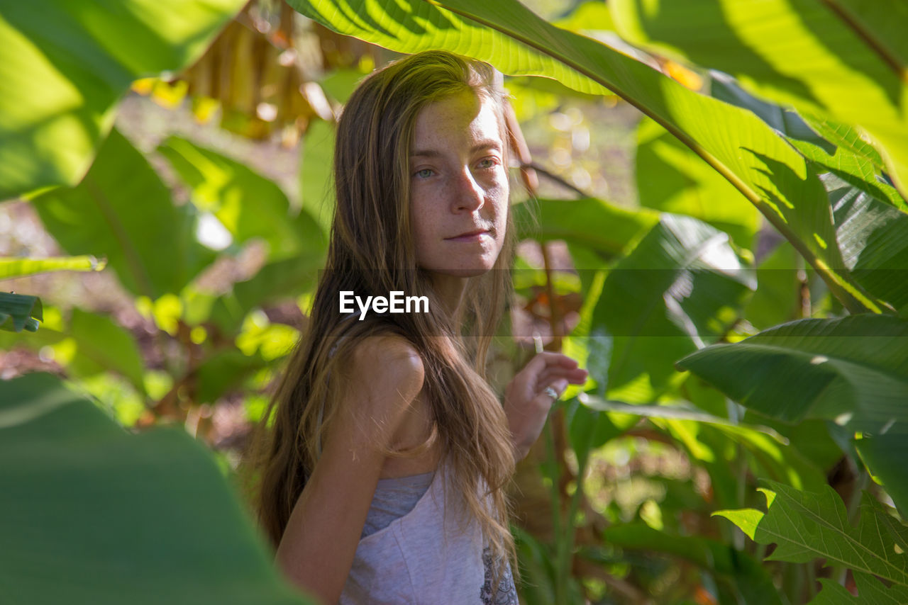Teenage girl standing amidst plants