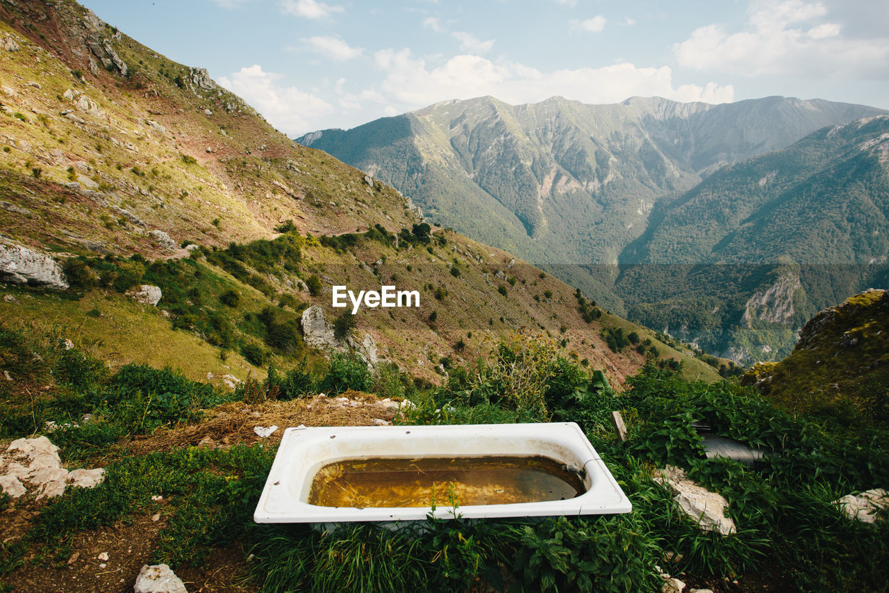 Old bath tub for relaxing with landscape view of mountain peaks. green calm enviroment for leasure.