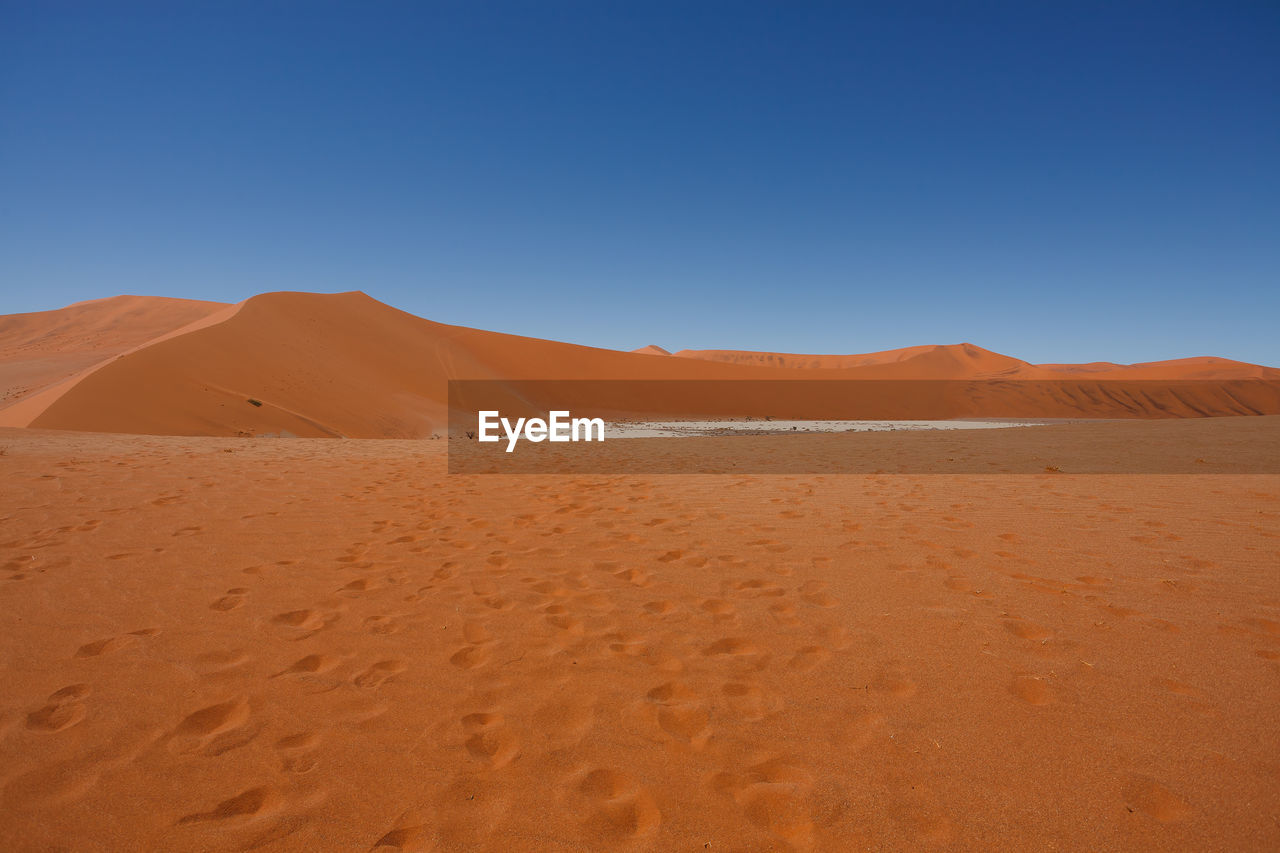 SAND DUNE IN DESERT AGAINST CLEAR BLUE SKY