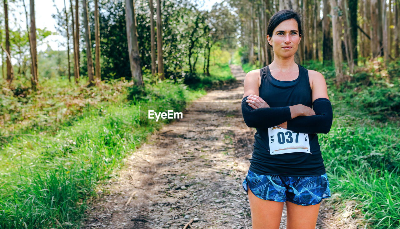 Woman standing with marathon bib in forest
