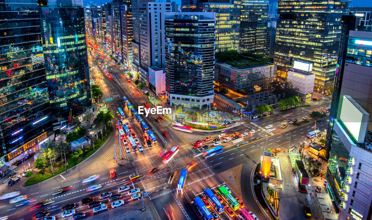 High angle view of vehicles on road in illuminated city at night