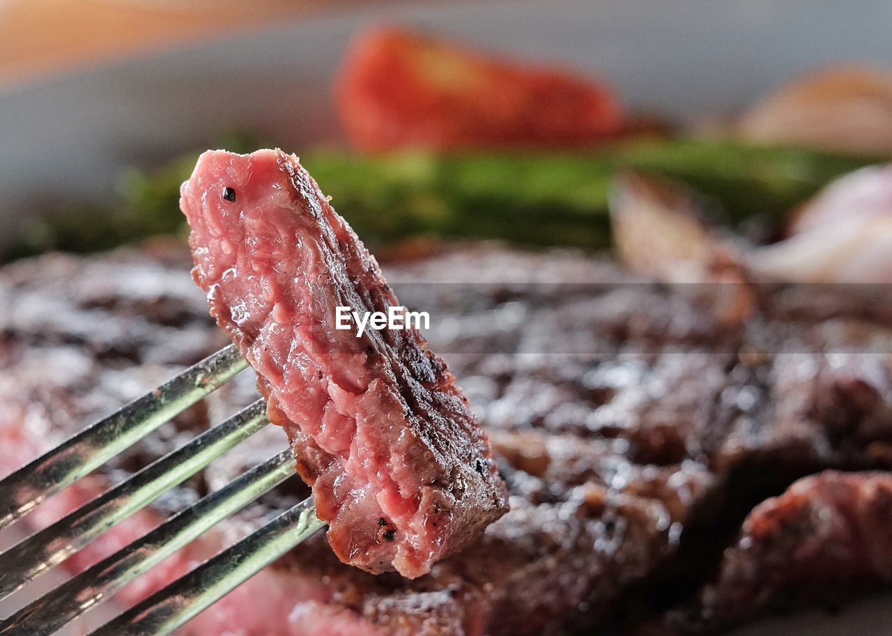 Close-up of fork in meat