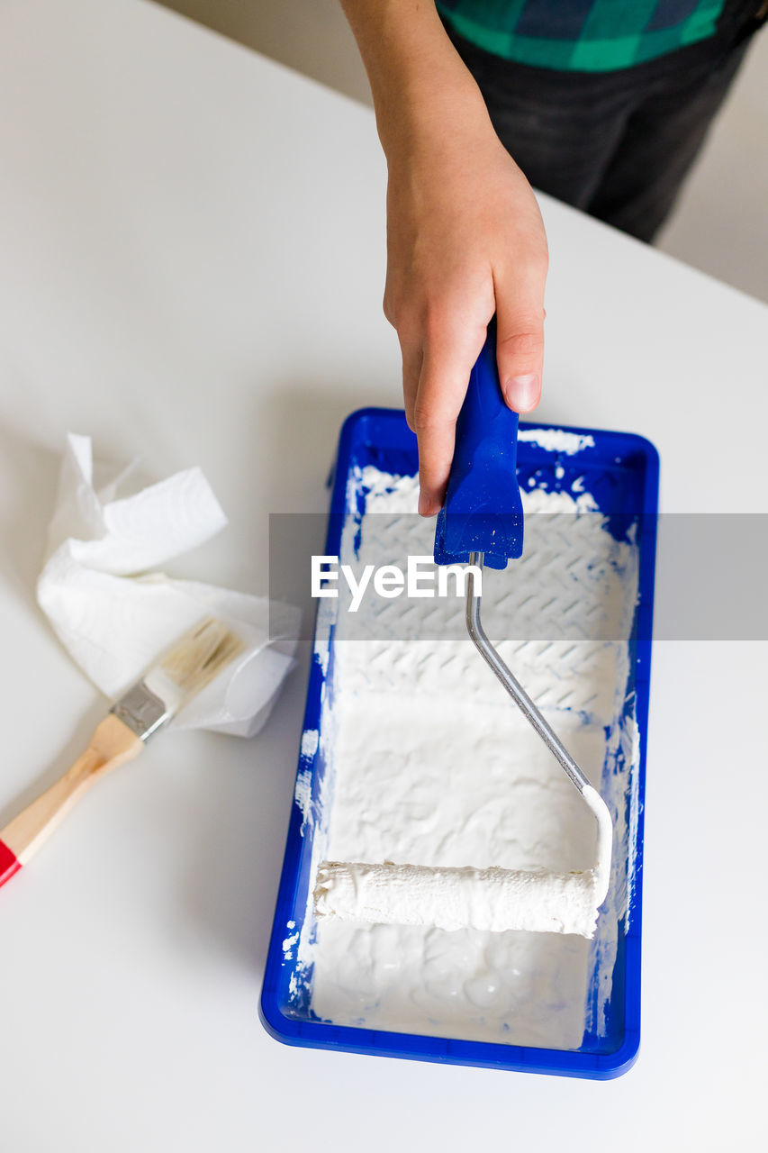 cropped hand of person cleaning brush on table