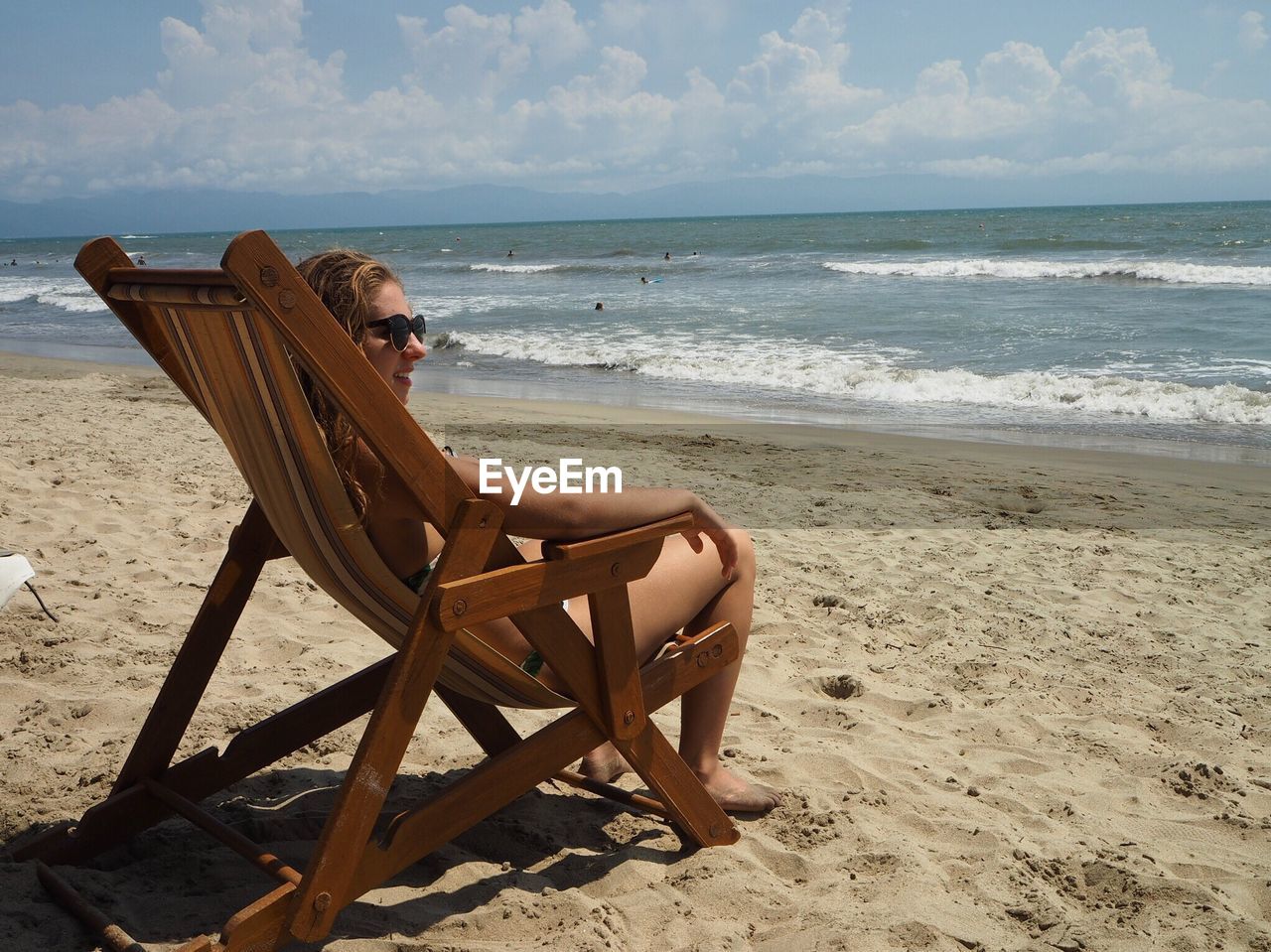 Woman sitting on chair at beach