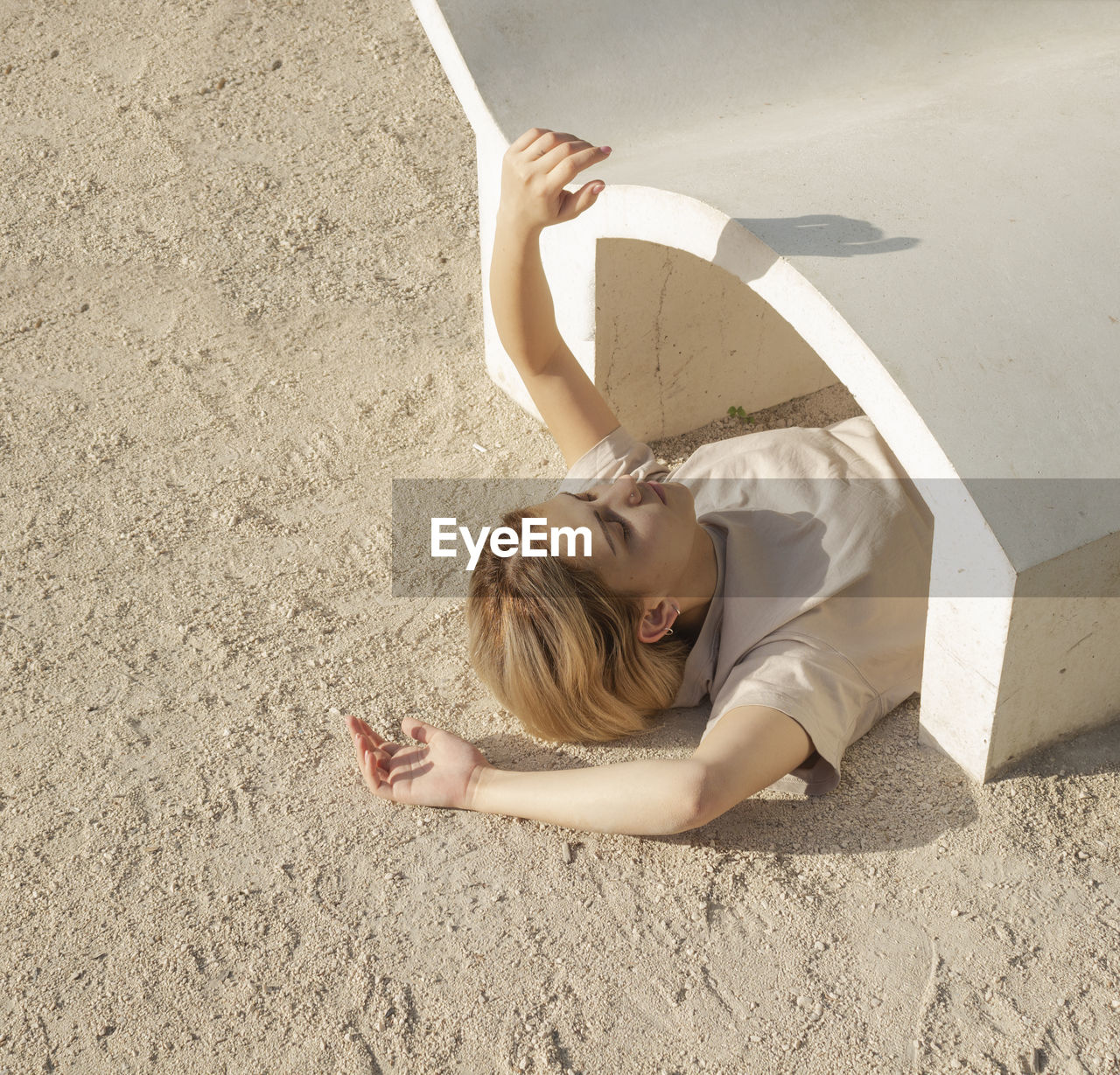 High angle view of woman lying down on sand