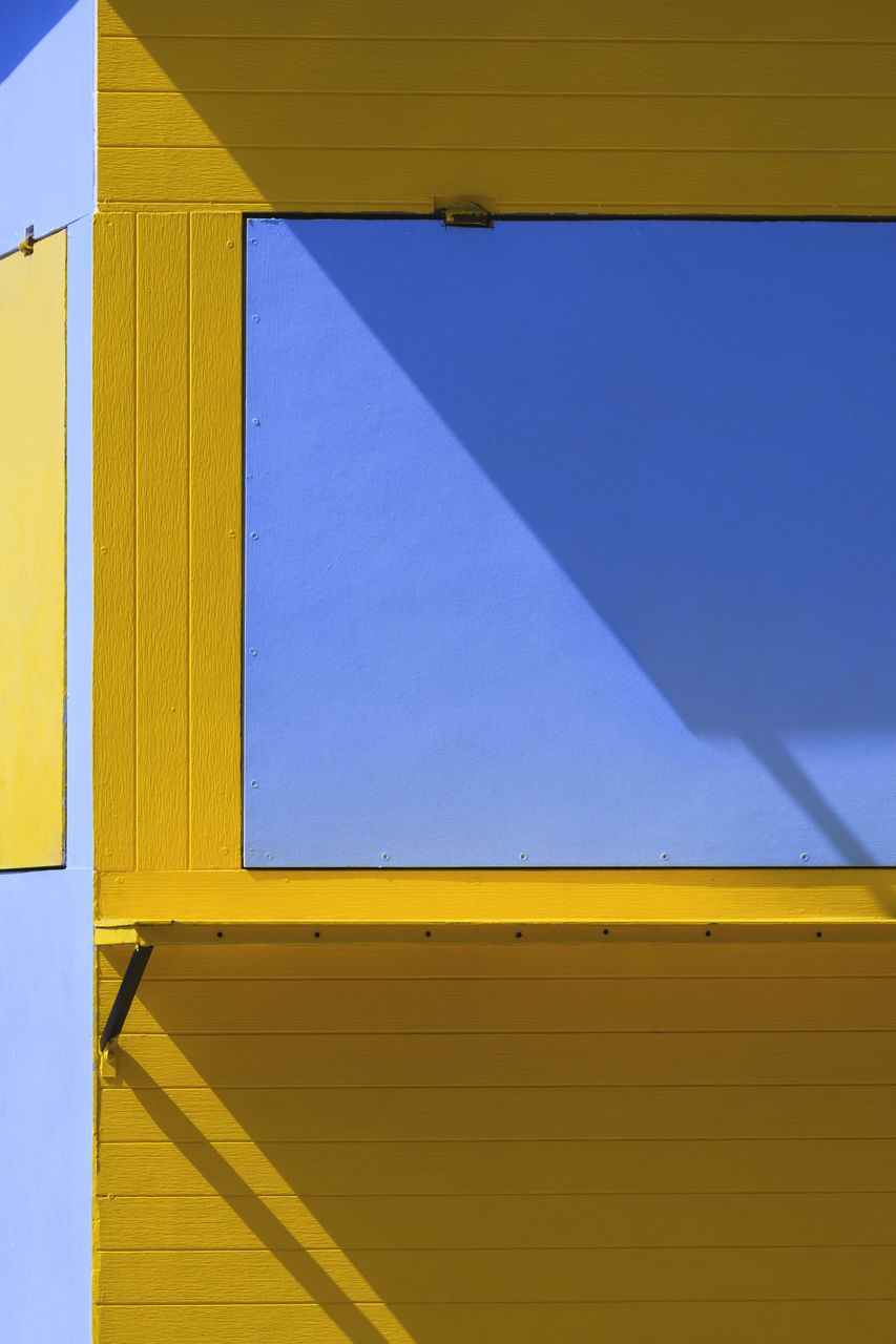 Sunlight and shadow on yellow and blue kiosk