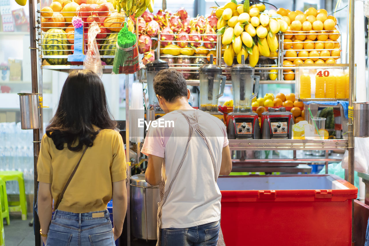 Thailand is khao san road. asian women tourists are buying juice, street food of thailand concept