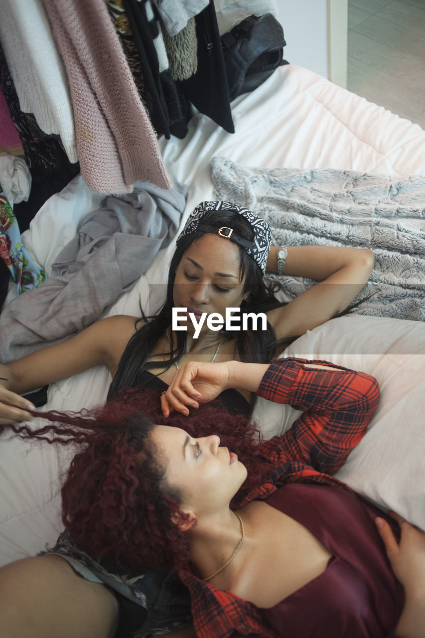Two friends lying on a bed together