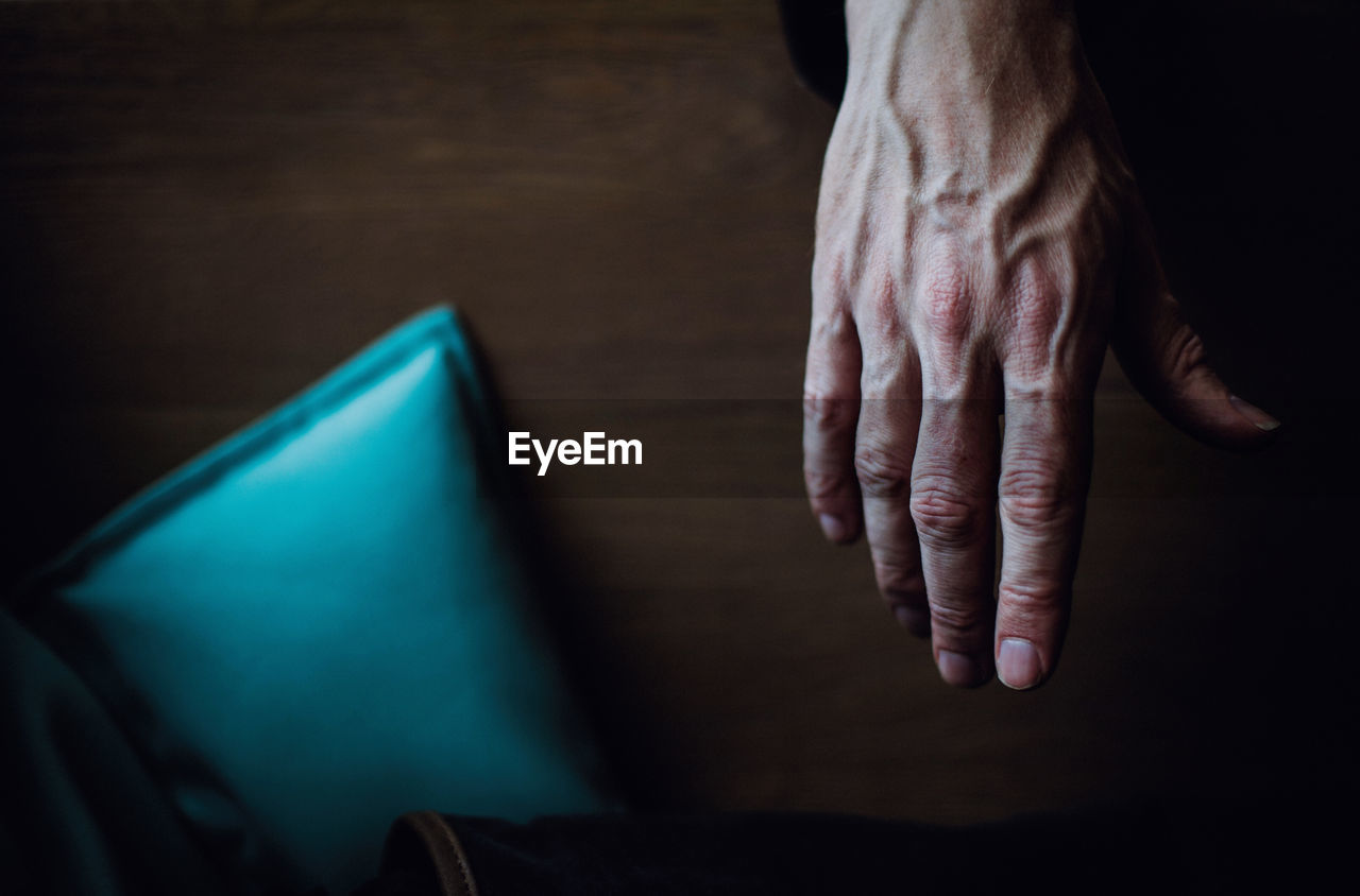 Cropped hand of man over wooden table
