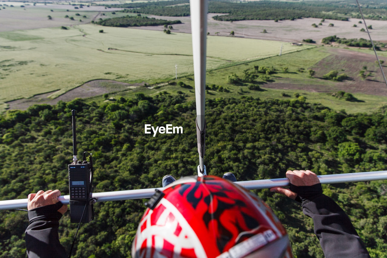 Cropped image of person powered hang gliding over landscape
