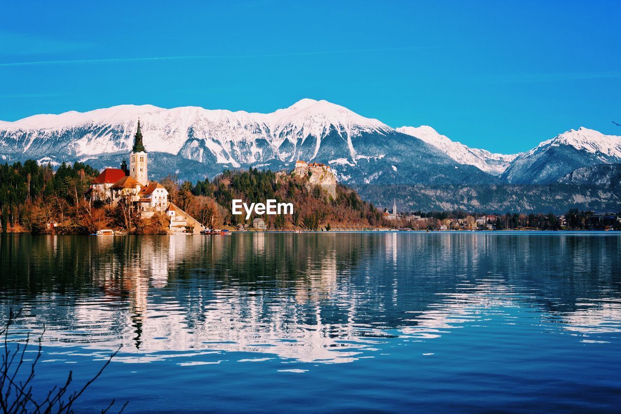 SCENIC VIEW OF LAKE AND SNOWCAPPED MOUNTAINS AGAINST CLEAR BLUE SKY