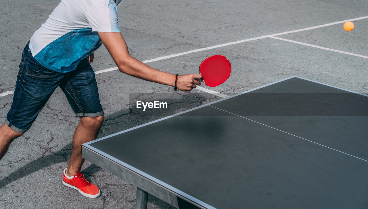 Low section of man playing table tennis