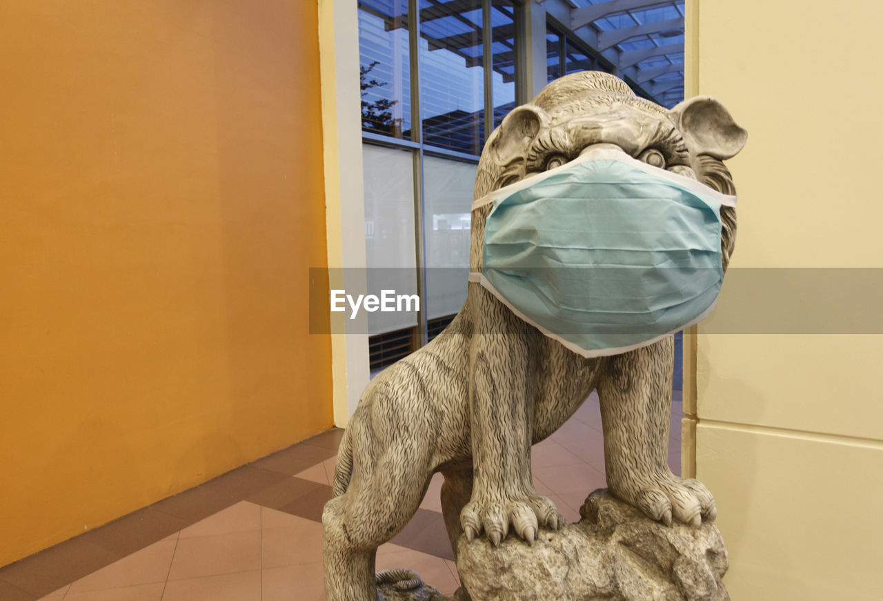 A lion statue using face mask at a shopping mall in bogor, west java, indonesia