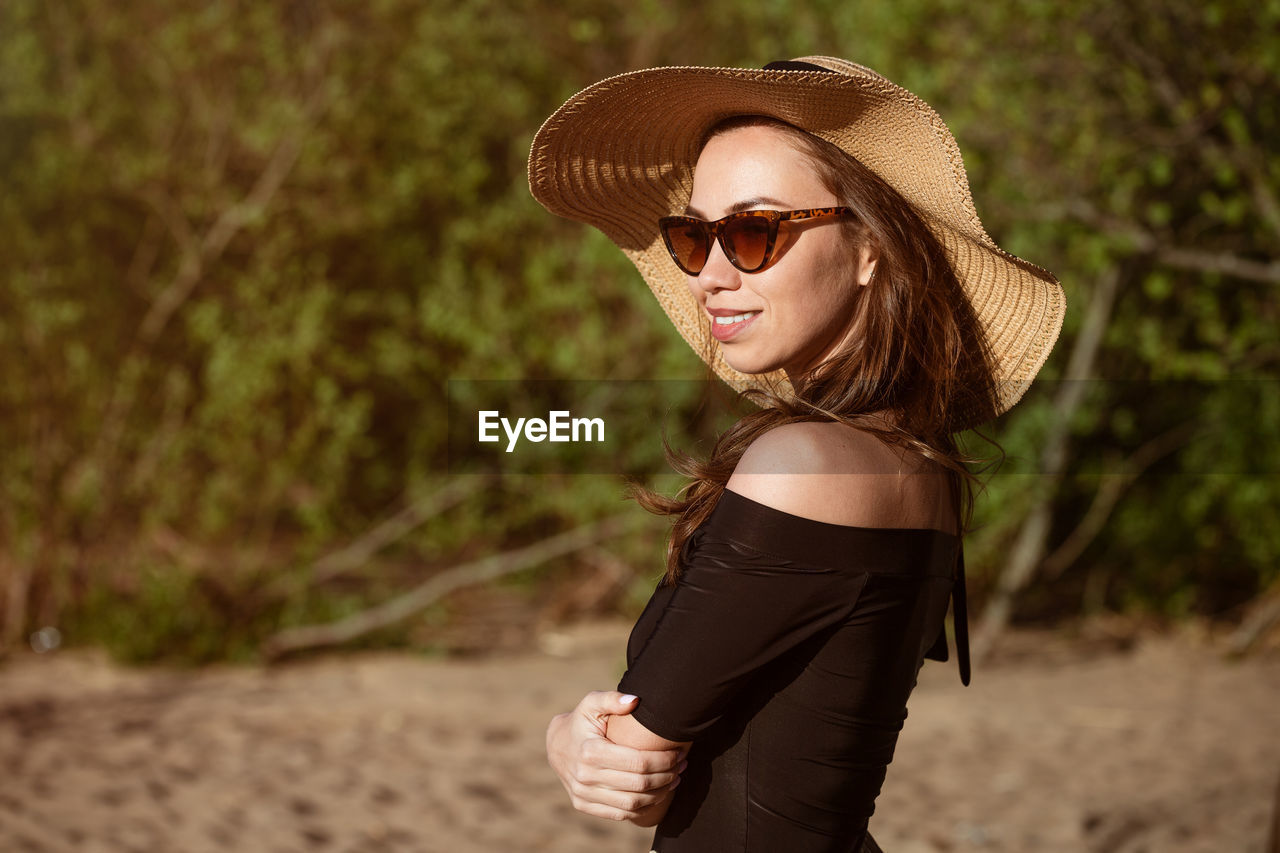 portrait of young woman wearing sunglasses while standing outdoors