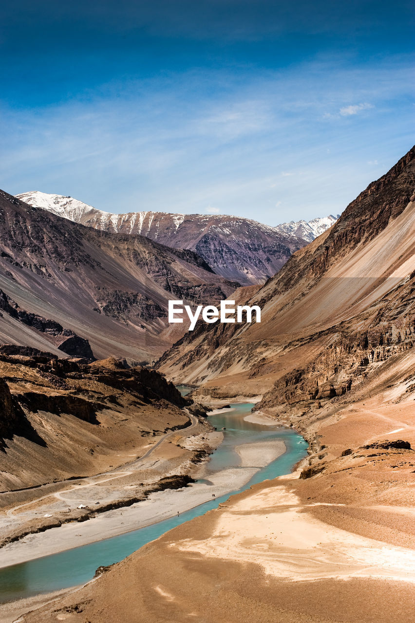 Scenic view of zanskar river amidst mountains against sky